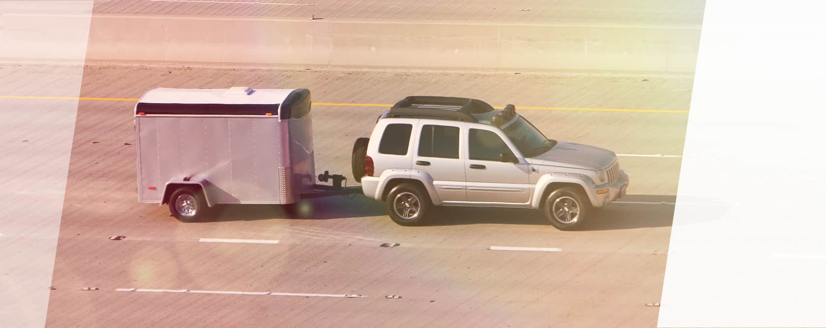 Ein Anhänger an einem SUV auf der Straße